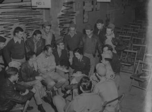 Doris Fleeson in her uniform as a war correspondent, surrounded by members of the US 100th Bomb Group